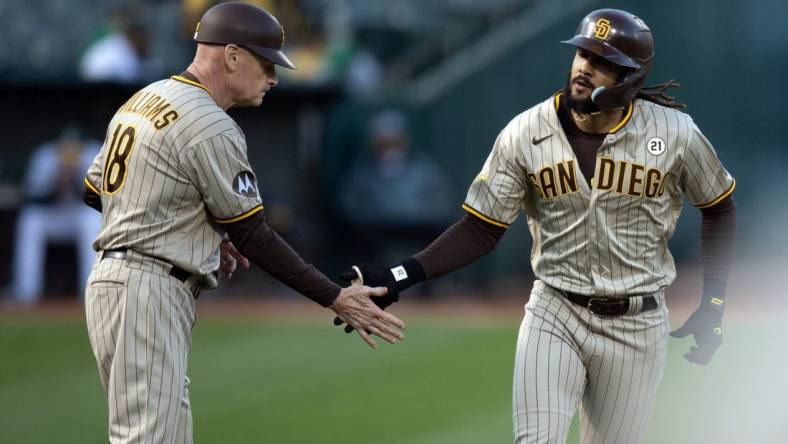 Sep 15, 2023; Oakland, California, USA; San Diego Padres right fielder Fernando Tatis Jr. (right) gets a congratulatory handshake from third base coach Matt Williams (18) after hitting a solo home run against the Oakland Athletics during the first inning at Oakland-Alameda County Coliseum. Mandatory Credit: D. Ross Cameron-USA TODAY Sports