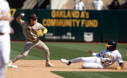 Sep 16, 2023; Oakland, California, USA; San Diego Padres second baseman Ha-Seong Kim (7) throws over Oakland Athletics center fielder Lawrence Butler (22) to complete a double play during the sixth inning at Oakland-Alameda County Coliseum. Mandatory Credit: D. Ross Cameron-USA TODAY Sports