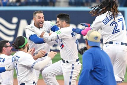 Sep 16, 2023; Toronto, Ontario, CAN; Toronto Blue Jays left fielder Whit Merrifield (15) celebrates with teammates after driving in the winning run against the Boston Red Sox in the 13th inning at Rogers Centre. Mandatory Credit: Dan Hamilton-USA TODAY Sports