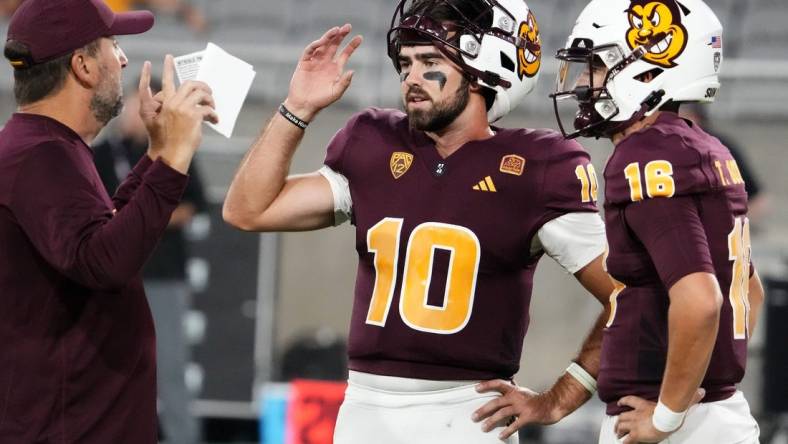 Arizona State Sun Devils offensive coordinator Beau Baldwin talks to his quarterbacks Drew Pyne (10) and Trenton Bourguet (16) during pregame warms-up before playing the Fresno State Bulldogs at Mountain America Stadium in Tempe on Sept. 16, 2023.