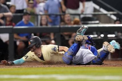 Sep 16, 2023; Phoenix, Arizona, USA; Arizona Diamondbacks pinch hitter Evan Longoria (3) slides at home and beats the tag of Chicago Cubs catcher Yan Gomes (15) to score the game winning run during the 13th inning at Chase Field. Mandatory Credit: Joe Camporeale-USA TODAY Sports