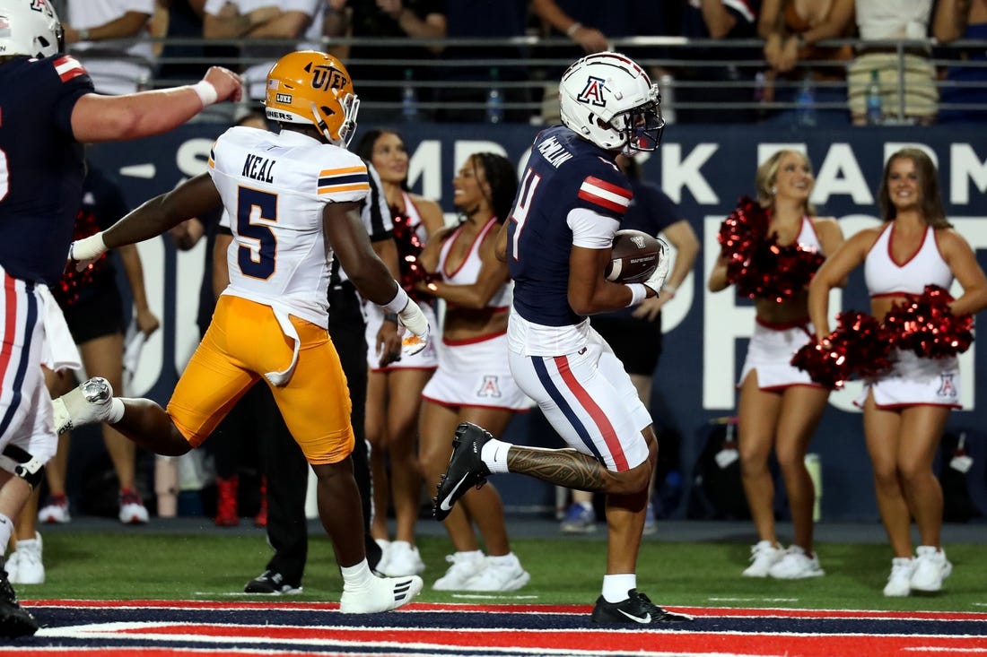 Sep 16, 2023; Tucson, Arizona, USA; Arizona Wildcats wide receiver Tetairoa McMillan (4) makes a touchdown catch against UTEP Miners linebacker James Neal (5) during the first half at Arizona Stadium. Mandatory Credit: Zachary BonDurant-USA TODAY Sports