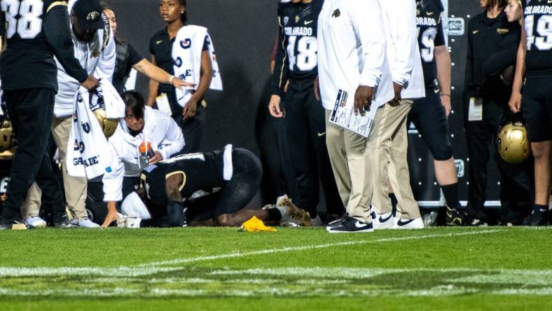 CU football's sophomore athlete Travis Hunter crumples in pain as a yellow penalty flag hits the ground following an illegal hit along the sideline by a CSU defender during the Rocky Mountain Showdown on Sept. 16, 2023 at Folsom Field in Boulder, Colo.