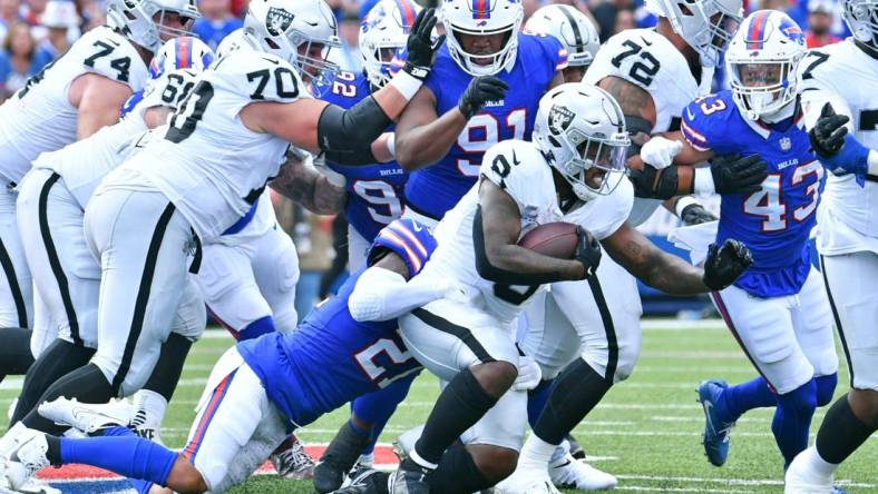 Sep 17, 2023; Orchard Park, New York, USA; Las Vegas Raiders running back Josh Jacobs (8) is tackled by Buffalo Bills safety Jordan Poyer (21) in the second quarter at Highmark Stadium. Mandatory Credit: Mark Konezny-USA TODAY Sports