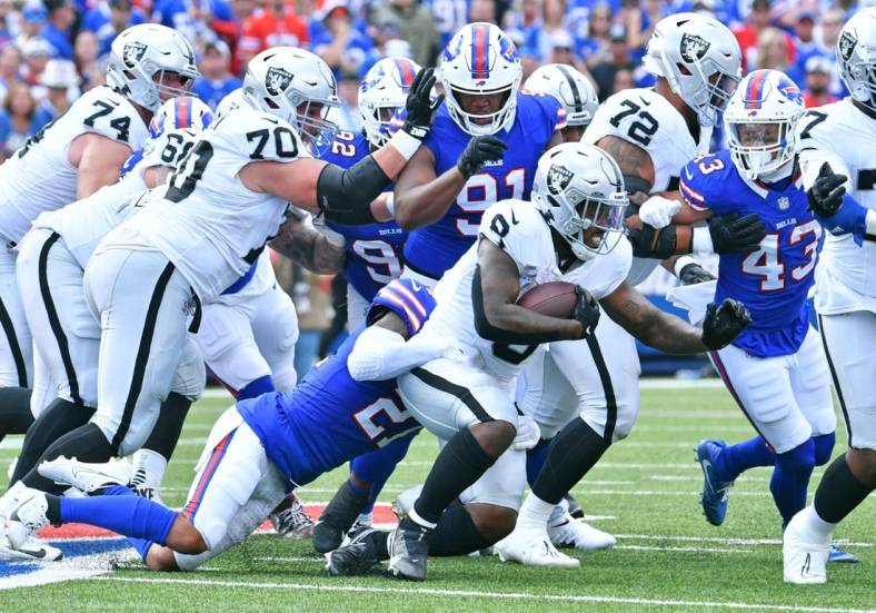 Sep 17, 2023; Orchard Park, New York, USA; Las Vegas Raiders running back Josh Jacobs (8) is tackled by Buffalo Bills safety Jordan Poyer (21) in the second quarter at Highmark Stadium. Mandatory Credit: Mark Konezny-USA TODAY Sports