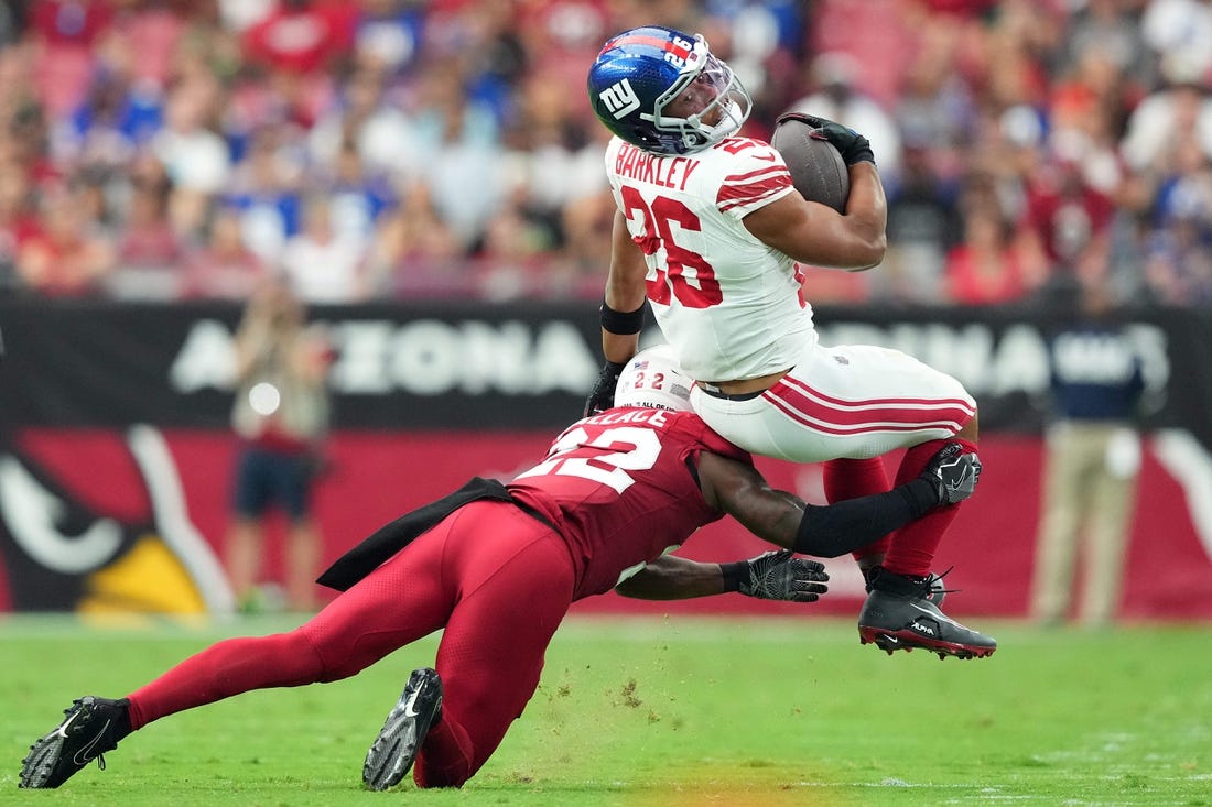 Sep 17, 2023; Glendale, Arizona, USA; Arizona Cardinals safety K'Von Wallace (22) tackles New York Giants running back Saquon Barkley (26) during the first half at State Farm Stadium. Mandatory Credit: Joe Camporeale-USA TODAY Sports