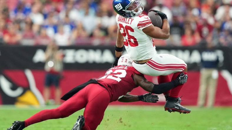 Sep 17, 2023; Glendale, Arizona, USA; Arizona Cardinals safety K'Von Wallace (22) tackles New York Giants running back Saquon Barkley (26) during the first half at State Farm Stadium. Mandatory Credit: Joe Camporeale-USA TODAY Sports