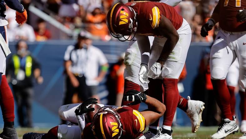 Sep 17, 2023; Denver, Colorado, USA; Washington Commanders tight end Logan Thomas (82) lies in the end zone after scoring a touchdown as wide receiver Curtis Samuel (4) stands over him in the second quarter against the Denver Broncos at Empower Field at Mile High. Mandatory Credit: Isaiah J. Downing-USA TODAY Sports