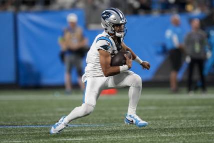 Sep 18, 2023; Charlotte, North Carolina, USA; Carolina Panthers quarterback Bryce Young (9) keeps the ball running out of the pocket against the New Orleans Saints during the second half at Bank of America Stadium. Mandatory Credit: Jim Dedmon-USA TODAY Sports