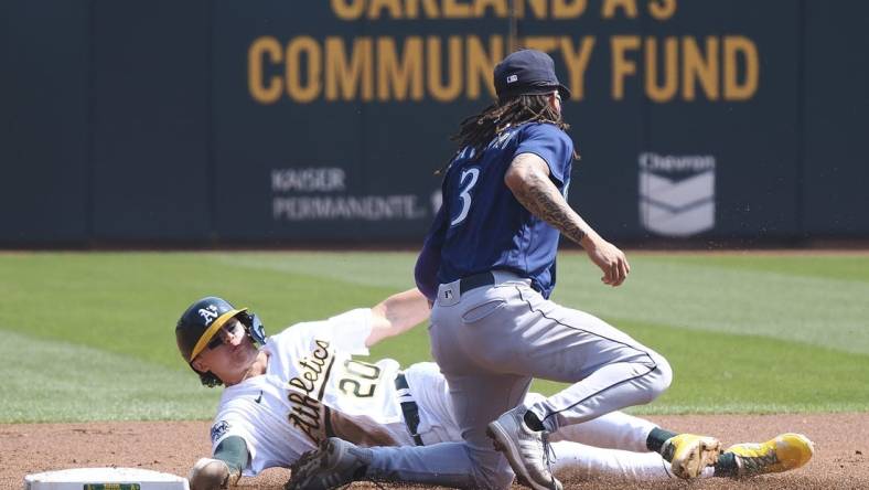 Sep 20, 2023; Oakland, California, USA; Oakland Athletics second baseman Zack Gelof (20) steals second base against Seattle Mariners shortstop J.P. Crawford (3) during the first inning at Oakland-Alameda County Coliseum. Mandatory Credit: Kelley L Cox-USA TODAY Sports