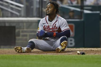 Sep 21, 2023; Washington, District of Columbia, USA; Atlanta Braves second baseman Ozzie Albies (1) sits at home plate after scoring a run on a single by Braves third baseman Austin Riley (not pictured) against the Washington Nationals during the third inning at Nationals Park. Mandatory Credit: Geoff Burke-USA TODAY Sports