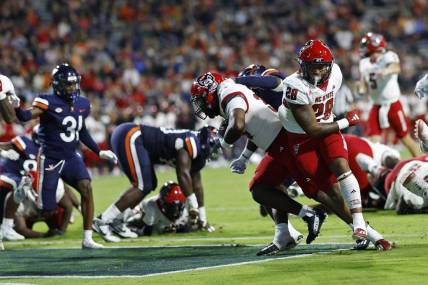 Sep 22, 2023; Charlottesville, Virginia, USA; North Carolina State Wolfpack running back Delbert Mimms III (34) scores a touchdown against the Virginia Cavaliers during the second quarter at Scott Stadium. Mandatory Credit: Geoff Burke-USA TODAY Sports