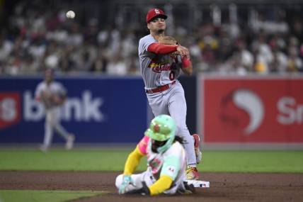Sep 22, 2023; San Diego, California, USA; St. Louis Cardinals shortstop Masyn Winn (0) throws to first base after forcing out San Diego Padres right fielder Fernando Tatis Jr. (bottom) at second base to complete a double play during the fifth inning at Petco Park. Mandatory Credit: Orlando Ramirez-USA TODAY Sports
