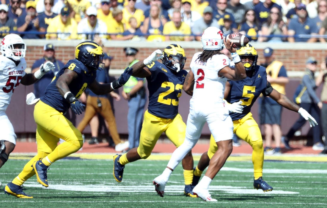 Michigan defenders, from left, Derrick Moore, Michael Barrett and Josaiah Stewart rush against Rutgers quarterback Gavin Wimsatt during the second half of Michigan's 31-7 win on Saturday, Sept. 23 2023, in Ann Arbor.