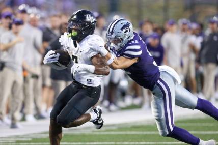 Sep 23, 2023; Manhattan, Kansas, USA; Kansas State Wildcats linebacker Jake Clifton (31) tries to tackle UCF Knights running back RJ Harvey (7) during the first quarter at Bill Snyder Family Football Stadium. Mandatory Credit: Scott Sewell-USA TODAY Sports