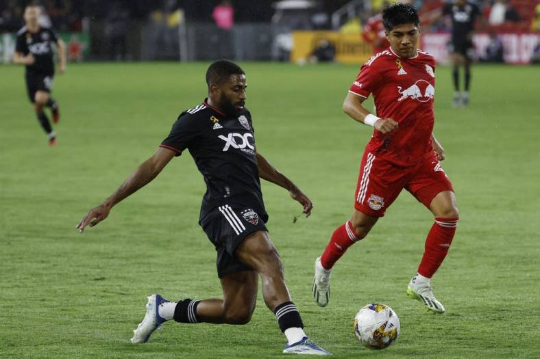 Sep 23, 2023; Washington, District of Columbia, USA; D.C. United defender Ruan (2) passes the ball as New York Red Bulls midfielder Omir Fernandez (21) chases in the first half at Audi Field. Mandatory Credit: Geoff Burke-USA TODAY Sports