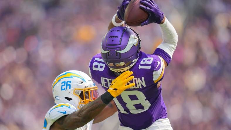 Sep 24, 2023; Minneapolis, Minnesota, USA; Minnesota Vikings wide receiver Justin Jefferson (18) catches a pass against the Los Angeles Chargers cornerback Asante Samuel Jr. (26) in the second quarter at U.S. Bank Stadium. Mandatory Credit: Brad Rempel-USA TODAY Sports