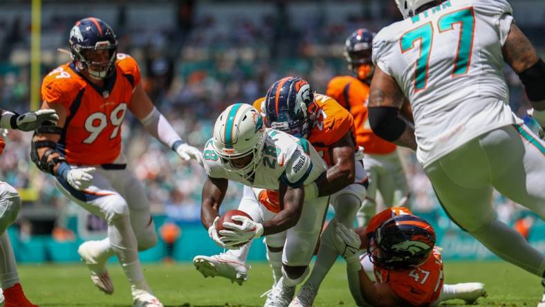 Sep 24, 2023; Miami Gardens, Florida, USA;  Miami Dolphins running back De'Von Achane (28) scores a touchdown  against the Denver Broncos in the first quarter at Hard Rock Stadium. Mandatory Credit: Nathan Ray Seebeck-USA TODAY Sports