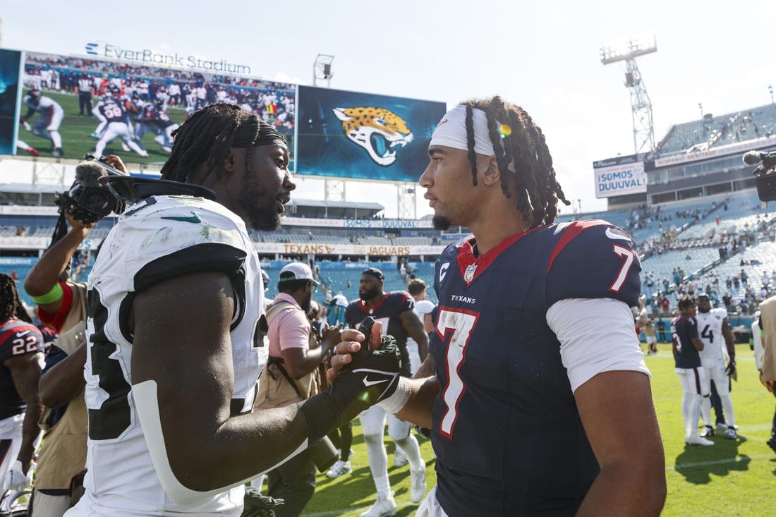 Sep 24, 2023; Jacksonville, Florida, USA; Jacksonville Jaguars linebacker Devin Lloyd (33) and Houston Texans quarterback C.J. Stroud (7) after the game at EverBank Stadium. Mandatory Credit: Morgan Tencza-USA TODAY Sports