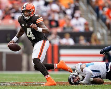 Cleveland Browns quarterback Deshaun Watson (4) escapes from Tennessee Titans safety Amani Hooker (37) during the second quarter in Cleveland, Ohio, Sunday, Sept. 24, 2023.