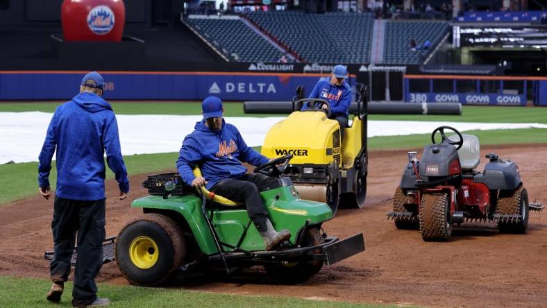 Sep 26, 2023; New York City, New York, USA; Members of the grounds crew attempt to dry the field during a delayed start before a game between the New York Mets and Miami Marlins at Citi Field. Mandatory Credit: Brad Penner-USA TODAY Sports