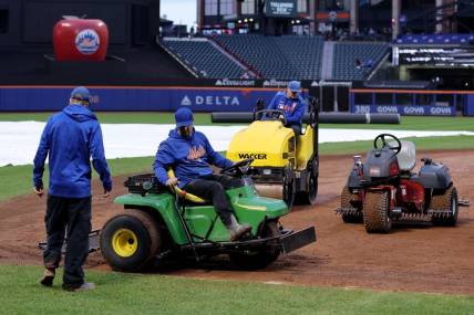 Sep 26, 2023; New York City, New York, USA; Members of the grounds crew attempt to dry the field during a delayed start before a game between the New York Mets and Miami Marlins at Citi Field. Mandatory Credit: Brad Penner-USA TODAY Sports