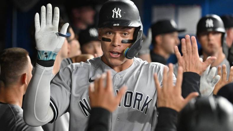 Sep 27, 2023; Toronto, Ontario, CAN;  New York Yankees right fielder Aaron Judge (99) celebrates in the dugout with team mates after hitting a two run home run against the Toronto Blue Jays in the fourth inning at Rogers Centre. Mandatory Credit: Dan Hamilton-USA TODAY Sports