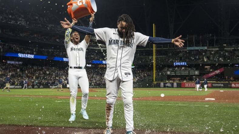 Sep 28, 2023; Seattle, Washington, USA; Seattle Mariners centerfielder Julio Rodriguez (44) dumps a bucket of water on shortstop J.P. Crawford (3) while celebrating after a game against the Texas Rangers at T-Mobile Park. Mandatory Credit: Stephen Brashear-USA TODAY Sports