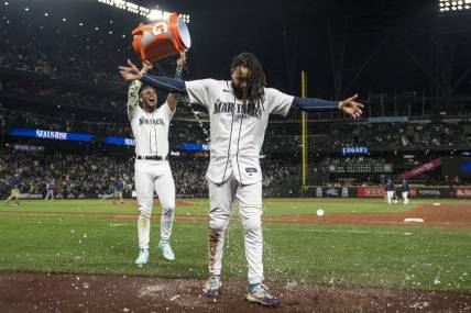 Sep 28, 2023; Seattle, Washington, USA; Seattle Mariners centerfielder Julio Rodriguez (44) dumps a bucket of water on shortstop J.P. Crawford (3) while celebrating after a game against the Texas Rangers at T-Mobile Park. Mandatory Credit: Stephen Brashear-USA TODAY Sports