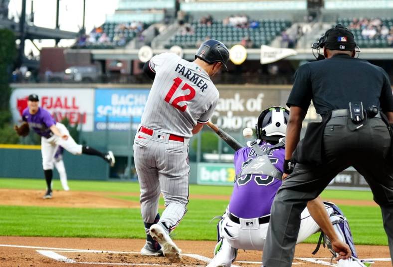 Sep 29, 2023; Denver, Colorado, USA; Minnesota Twins short stop Kyle Farmer (12) RBI singles in the first inning against the Colorado Rockies at Coors Field. Mandatory Credit: Ron Chenoy-USA TODAY Sports