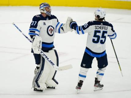 Apr 15, 2021; Toronto, Ontario, CAN; Winnipeg Jets forward Mark Scheifele (55) congratulates goaltender Connor Hellebuyck (37) on a win over the Toronto Maple Leafs during the third period at Scotiabank Arena. Mandatory Credit: John E. Sokolowski-USA TODAY Sports