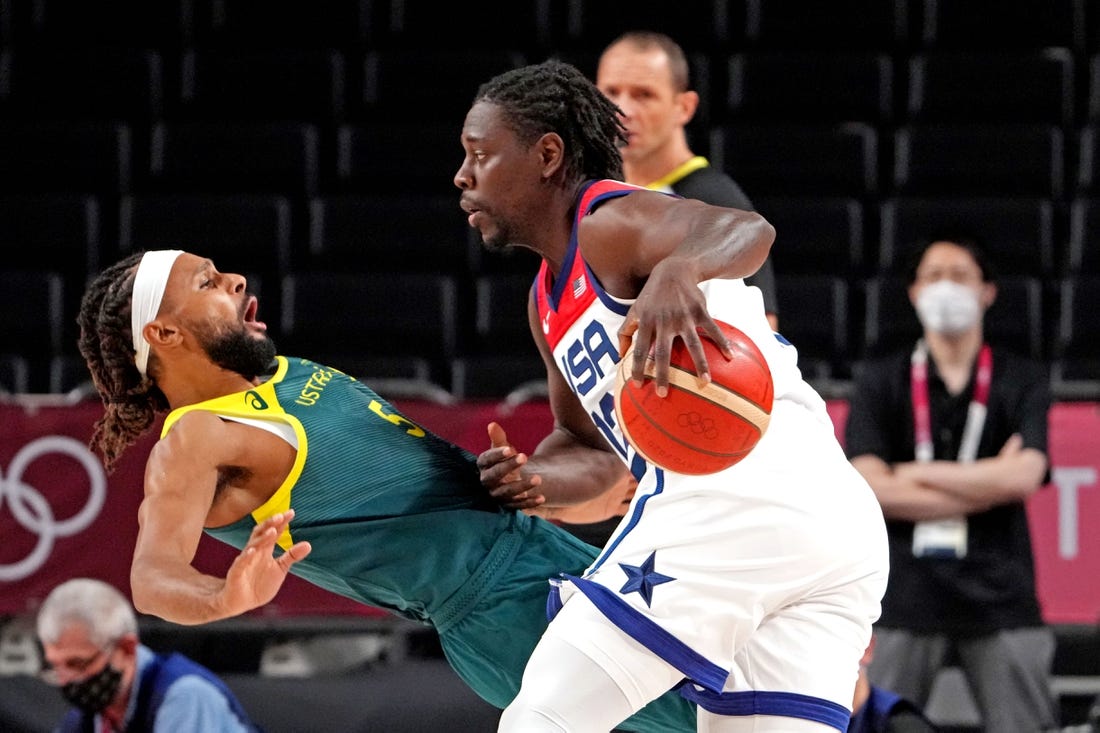 Aug 5, 2021; Saitama, Japan; United States guard Jrue Holiday (12) drives to the basket against Australia point guard Patty Mills (5) in the men's basketball semi final during the Tokyo 2020 Olympic Summer Games at Saitama Super Arena. Mandatory Credit: Kyle Terada-USA TODAY Sports