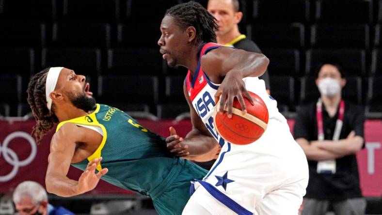 Aug 5, 2021; Saitama, Japan; United States guard Jrue Holiday (12) drives to the basket against Australia point guard Patty Mills (5) in the men's basketball semi final during the Tokyo 2020 Olympic Summer Games at Saitama Super Arena. Mandatory Credit: Kyle Terada-USA TODAY Sports