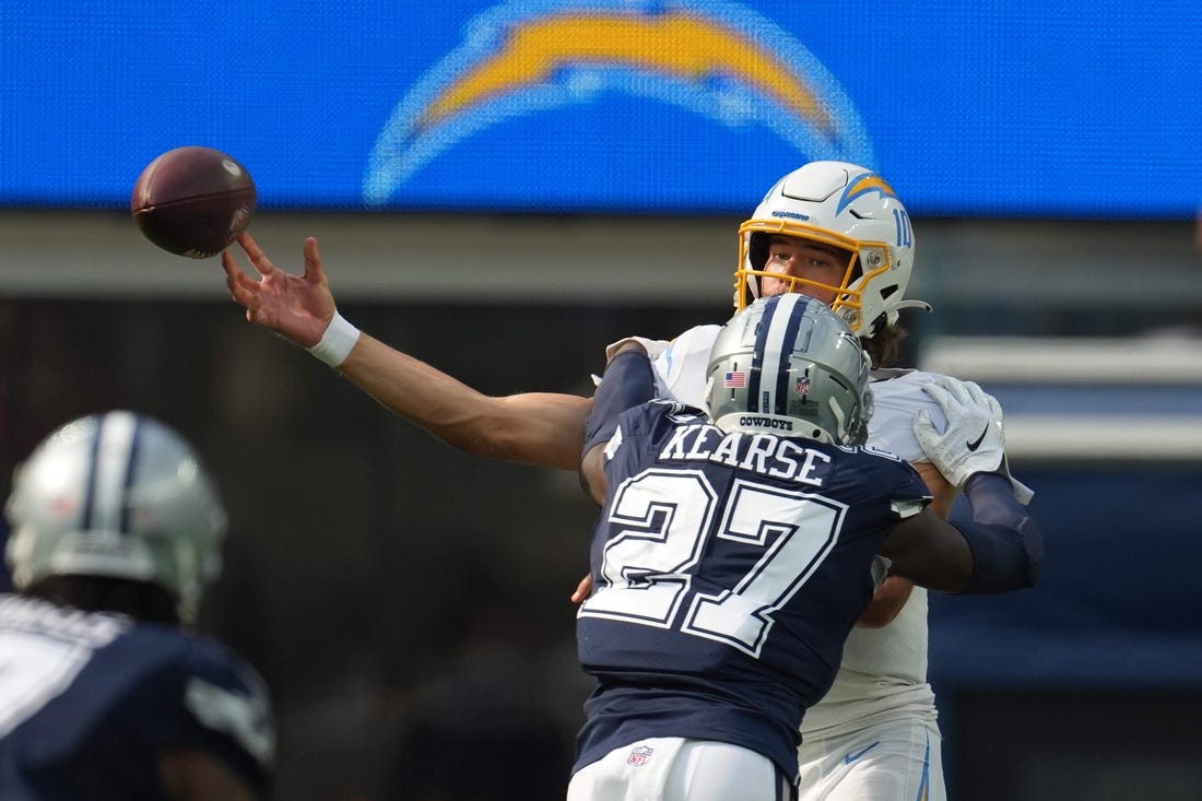 Sep 19, 2021; Inglewood, California, USA; Los Angeles Chargers quarterback Justin Herbert (10) is pressured by Dallas Cowboys safety Jayron Kearse (27) in the second half at SoFi Stadium. Mandatory Credit: Kirby Lee-USA TODAY Sports