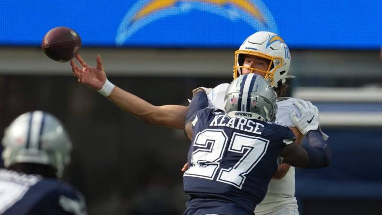 Sep 19, 2021; Inglewood, California, USA; Los Angeles Chargers quarterback Justin Herbert (10) is pressured by Dallas Cowboys safety Jayron Kearse (27) in the second half at SoFi Stadium. Mandatory Credit: Kirby Lee-USA TODAY Sports