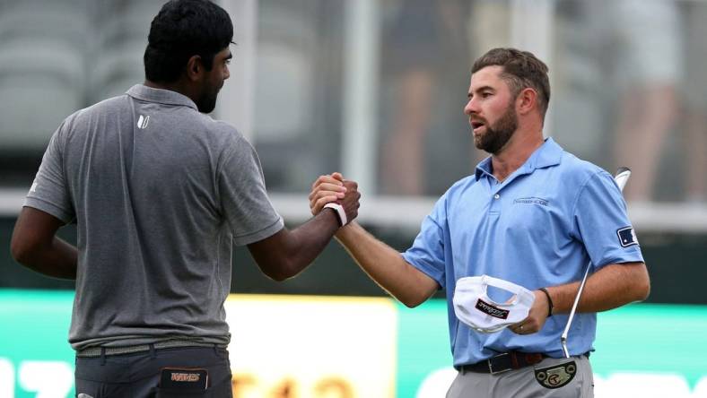 Oct 2, 2021; Jackson, Mississippi, USA; Sahith Theegala and Cameron Young shake hands on the 18th green after their third round of the Sanderson Farms Championship at the Country Club of Jackson. Mandatory Credit: Chuck Cook-USA TODAY Sports