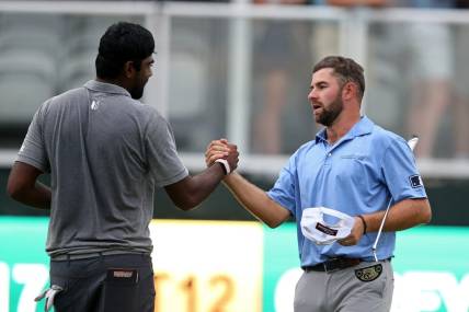 Oct 2, 2021; Jackson, Mississippi, USA; Sahith Theegala and Cameron Young shake hands on the 18th green after their third round of the Sanderson Farms Championship at the Country Club of Jackson. Mandatory Credit: Chuck Cook-USA TODAY Sports