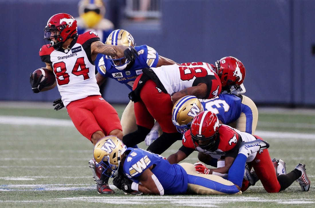 Aug 25, 2022; Winnipeg, Manitoba, CAN;  Calgary Stampeders wide receiver Reggie Begelton (84) is tackled by Winnipeg Blue Bombers defensive back Jamal Parker (45) during the first half at IG Field. Mandatory Credit: Bruce Fedyck-USA TODAY Sports
