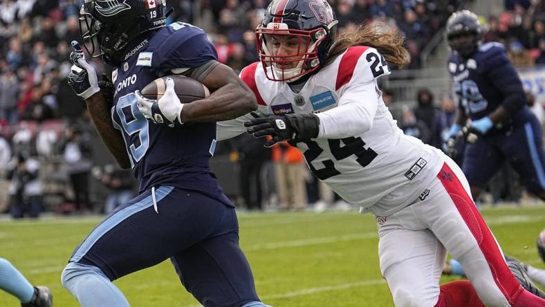 Nov 13, 2022; Toronto, Ontario, CAN; Montreal Alouettes defensiveback Marc-Antoine Dequoy (24) tries to tackle Toronto Argonauts wide receiver Kurleigh Gittens Jr. (19) after a pass reception during the first half at BMO Field. Mandatory Credit: John E. Sokolowski-USA TODAY Sports