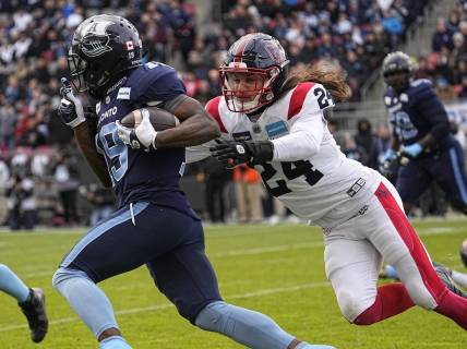 Nov 13, 2022; Toronto, Ontario, CAN; Montreal Alouettes defensiveback Marc-Antoine Dequoy (24) tries to tackle Toronto Argonauts wide receiver Kurleigh Gittens Jr. (19) after a pass reception during the first half at BMO Field. Mandatory Credit: John E. Sokolowski-USA TODAY Sports
