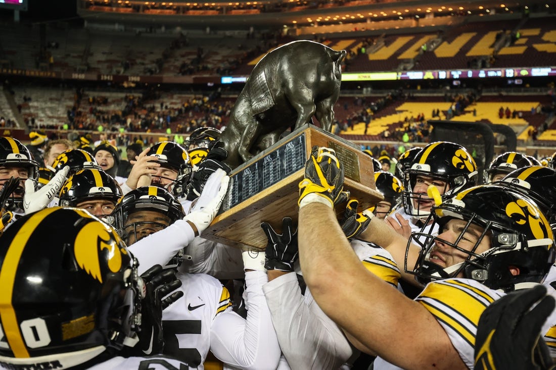 Nov 19, 2022; Minneapolis, Minnesota, USA; Iowa Hawkeyes players celebrate with the Floyd of Rosedale after defeating the Minnesota Golden Gophers at Huntington Bank Stadium. Mandatory Credit: Matt Krohn-USA TODAY Sports