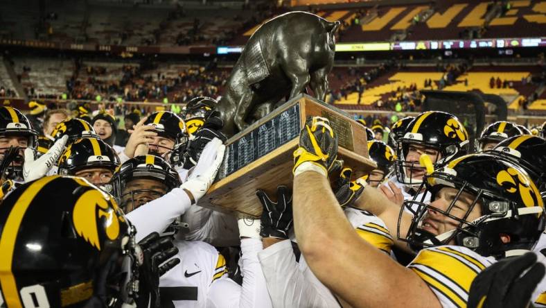 Nov 19, 2022; Minneapolis, Minnesota, USA; Iowa Hawkeyes players celebrate with the Floyd of Rosedale after defeating the Minnesota Golden Gophers at Huntington Bank Stadium. Mandatory Credit: Matt Krohn-USA TODAY Sports