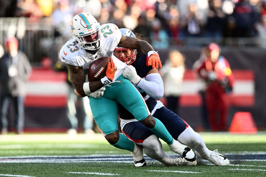 Jan 1, 2023; Foxborough, Massachusetts, USA; New England Patriots linebacker Jahlani Tavai (48) tackles Miami Dolphins running back Jeff Wilson Jr. (23)  during the first half at Gillette Stadium. Mandatory Credit: Brian Fluharty-USA TODAY Sports