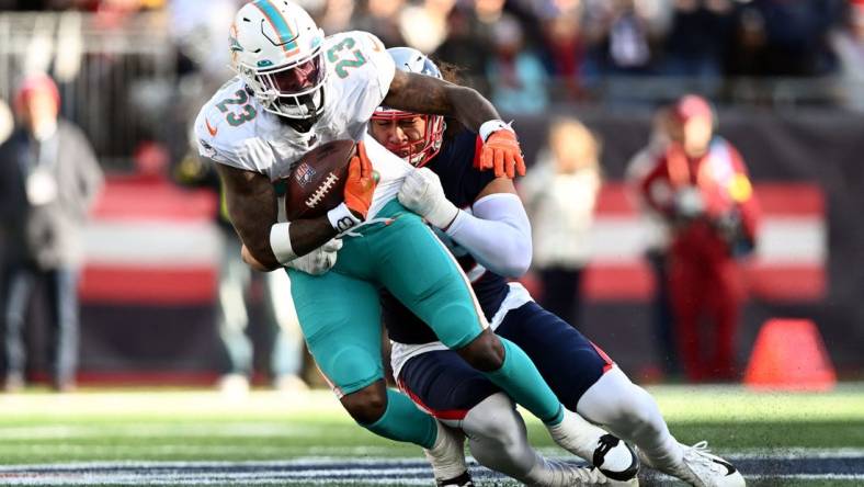 Jan 1, 2023; Foxborough, Massachusetts, USA; New England Patriots linebacker Jahlani Tavai (48) tackles Miami Dolphins running back Jeff Wilson Jr. (23)  during the first half at Gillette Stadium. Mandatory Credit: Brian Fluharty-USA TODAY Sports