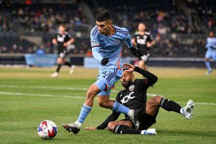 Mar 18, 2023; New York, New York, USA; New York City FC midfielder Santiago Rodriguez (10) jumps over a sliding D.C. United defender Ruan (2) during the first half at Yankee Stadium. Mandatory Credit: Mark Smith-USA TODAY Sports