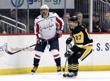Mar 25, 2023; Pittsburgh, Pennsylvania, USA;  Washington Capitals left wing Alex Ovechkin (8) and Pittsburgh Penguins center Sidney Crosby (87) look for the puck during the third period at PPG Paints Arena. Pittsburgh won 4-3. Mandatory Credit: Charles LeClaire-USA TODAY Sports