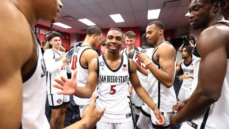 Apr 1, 2023; Houston, TX, USA; San Diego State Aztecs guard Lamont Butler (5) celebrates in the locker room with teammates in the semifinals of the Final Four in the 2023 NCAA Tournament against the Florida Atlantic Owls at NRG Stadium. Mandatory Credit: Jamie Schwaberow/Pool Photo-USA TODAY Sports