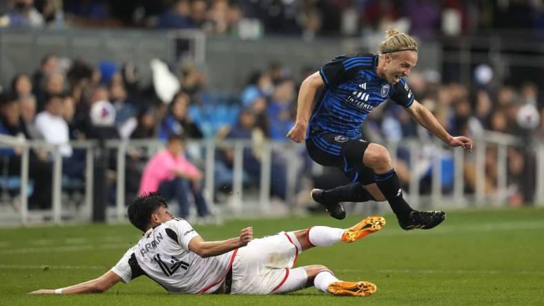 May 27, 2023; San Jose, California, USA; San Jose Earthquakes forward Tommy Thompson (right) leaps after a tackle by FC Dallas defender Marco Farfan (4) during the second half at PayPal Park. Mandatory Credit: Darren Yamashita-USA TODAY Sports