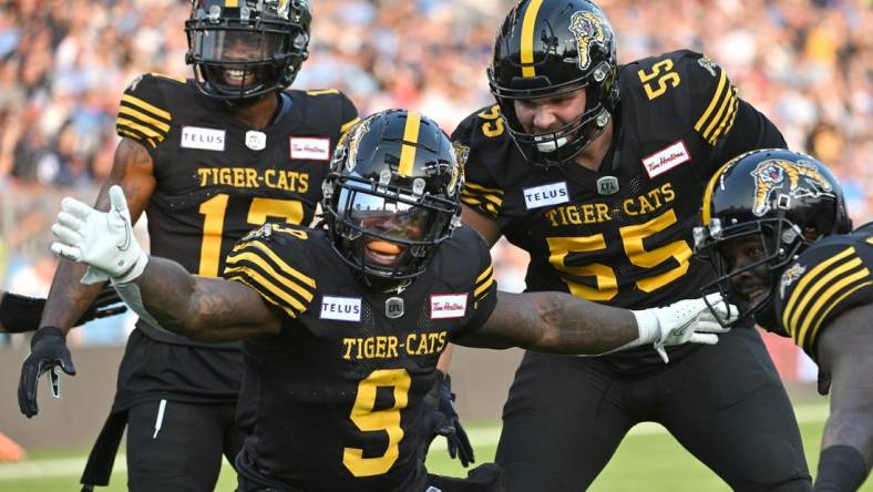 Jun 18, 2023; Toronto, Ontario, CAN;  Hamilton Tiger-Cats quarter James Butler (9) celebrates with teammates after scoring a touchdown against the Toronto Argonauts in the second quarter at BMO Field. Mandatory Credit: Dan Hamilton-USA TODAY Sports