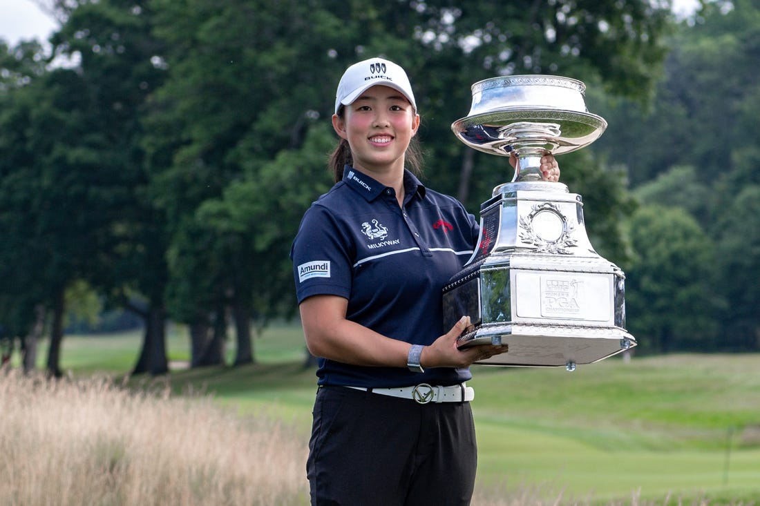 Jun 25, 2023; Springfield, New Jersey, USA; Ruoning Yin raises the championship trophy after winning the KPMG Women's PGA Championship golf tournament. Mandatory Credit: John Jones-USA TODAY Sports